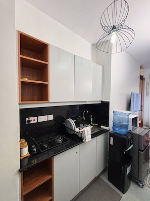 A compact kitchen with a gas stove, a microwave, and a water dispenser. - Studio, Kiambu Road, Nairobi (Nairobi)