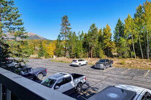 A parking lot with several vehicles, surrounded by trees and a mountain in the background. - Hikes + Hot Tub Soaks! Extended Silverthorne Stay (Silverthorne)