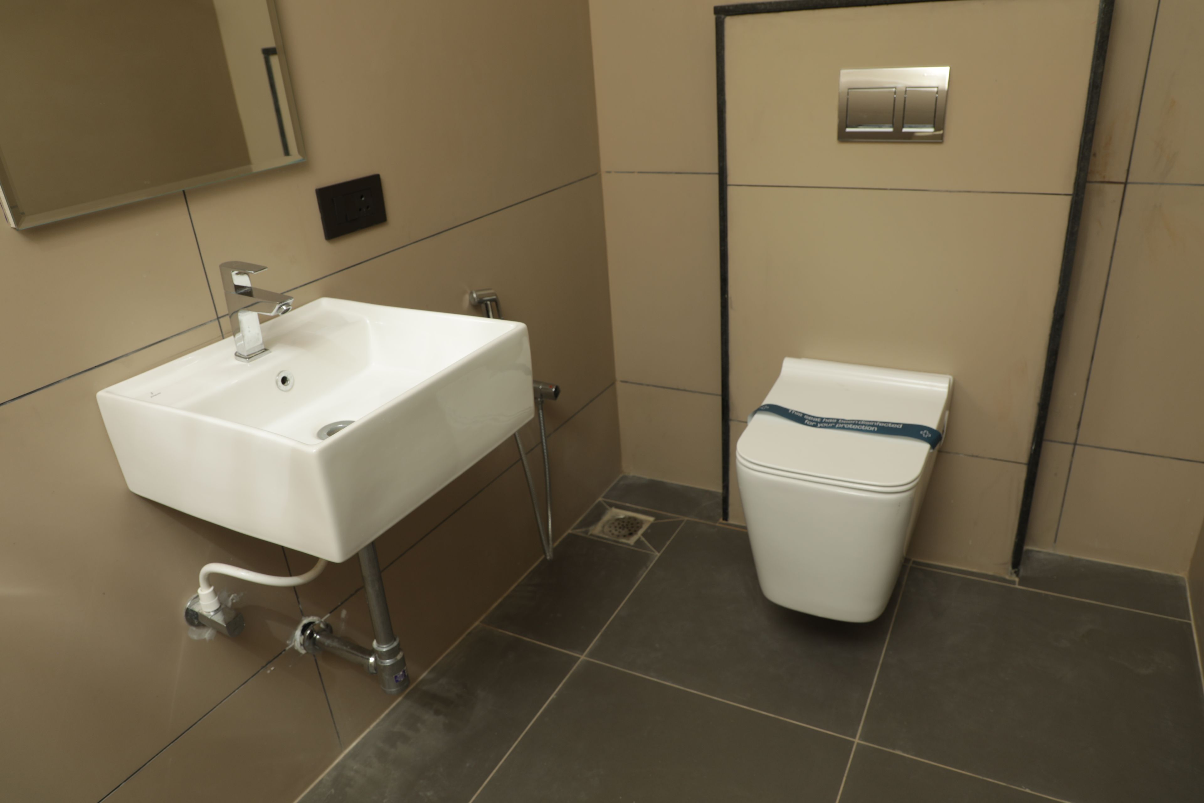 A bathroom with a white sink, a toilet, and a mirror.
