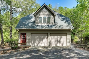 A two-car garage attached to a single-story building with a gable roof, surrounded by trees. - Dock, Hot Tub, Game Room! Lake Wateree Retreat (Camden)