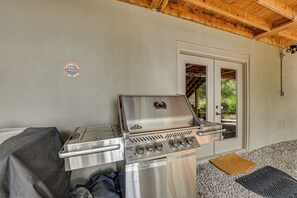 A portable gas grill with a stainless steel finish, a side burner, and a control panel with multiple knobs. - Dock, Hot Tub, Game Room! Lake Wateree Retreat (Camden)