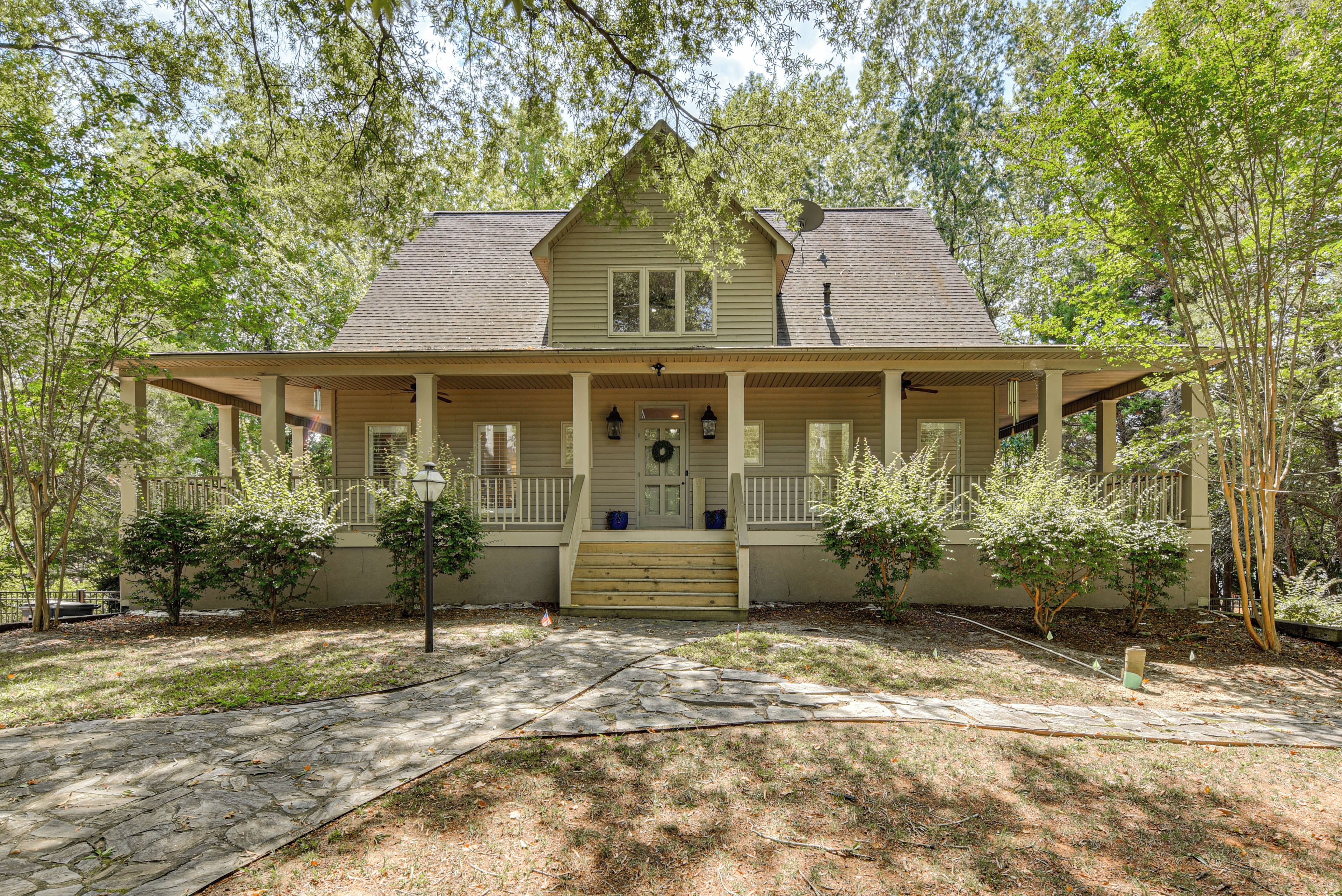 A two-story house with a porch, a front door, and a satellite dish.