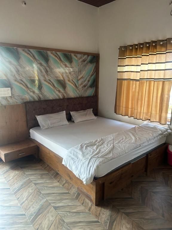 A bedroom with a wooden bed, a headboard with a marble-like design, and a herringbone-patterned floor.