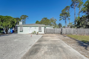 A single-story house with a gravel driveway and a wooden fence. - Beach Days + Chartered Boat Tours! PCB Retreat (Panama City Beach)