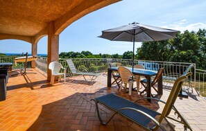An outdoor patio with a table, chairs, and an umbrella. - HAUT DE VILLA VUE MER AU CALME (CERVIONE)