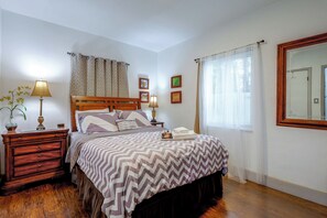 A neatly arranged bedroom with a bed, bedside tables, lamps, and a mirror. - 'Chez Mercedes Suite' w/ Terrace in North Miami! (North Miami Beach)