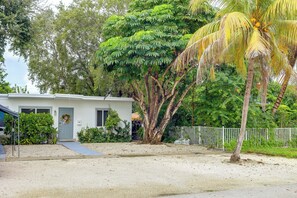 A residential property with a white house, a gravel driveway, a palm tree, and a white fence. - 'Chez Mercedes Suite' w/ Terrace in North Miami! (North Miami Beach)