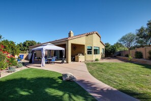 A house with a patio, a covered outdoor seating area, and a well-maintained lawn. - Desert Oasis: Tucson Home w/ Private Swim Spa (Tucson)