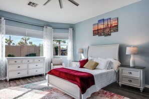 A bedroom with a bed, two bedside tables, a dresser, and a window with curtains. - Desert Oasis: Tucson Home w/ Private Swim Spa (Tucson)