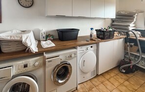 A laundry area with a washing machine, dryer, and stacked towels. - Vil. La Belle Vue avec piscice (Les Adrets de L' Ester)