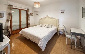 A bedroom with a bed, a desk, a chair, a television, and a window with curtains. - Vil. La Belle Vue avec piscice (Les Adrets de L' Ester)