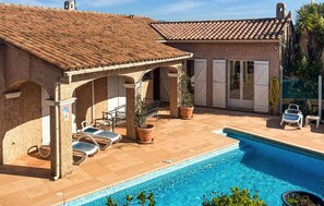 A poolside area with a tiled roof, outdoor seating, and a swimming pool. - Vil. La Belle Vue avec piscice (Les Adrets de L' Ester)