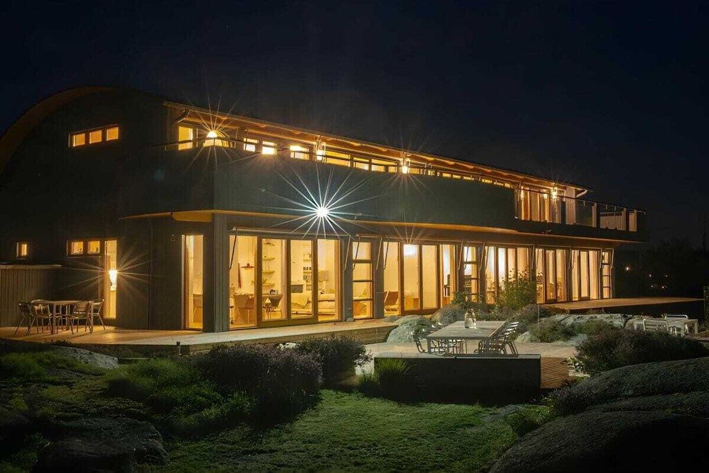 Un bâtiment moderne à deux étages, doté de grandes fenêtres et d’un intérieur bien éclairé.