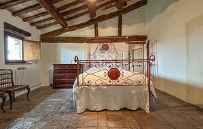A bedroom with a four-poster bed, wooden floor, and a window with a view. - 3 bedroom lovely home in Cagli (Cagli)