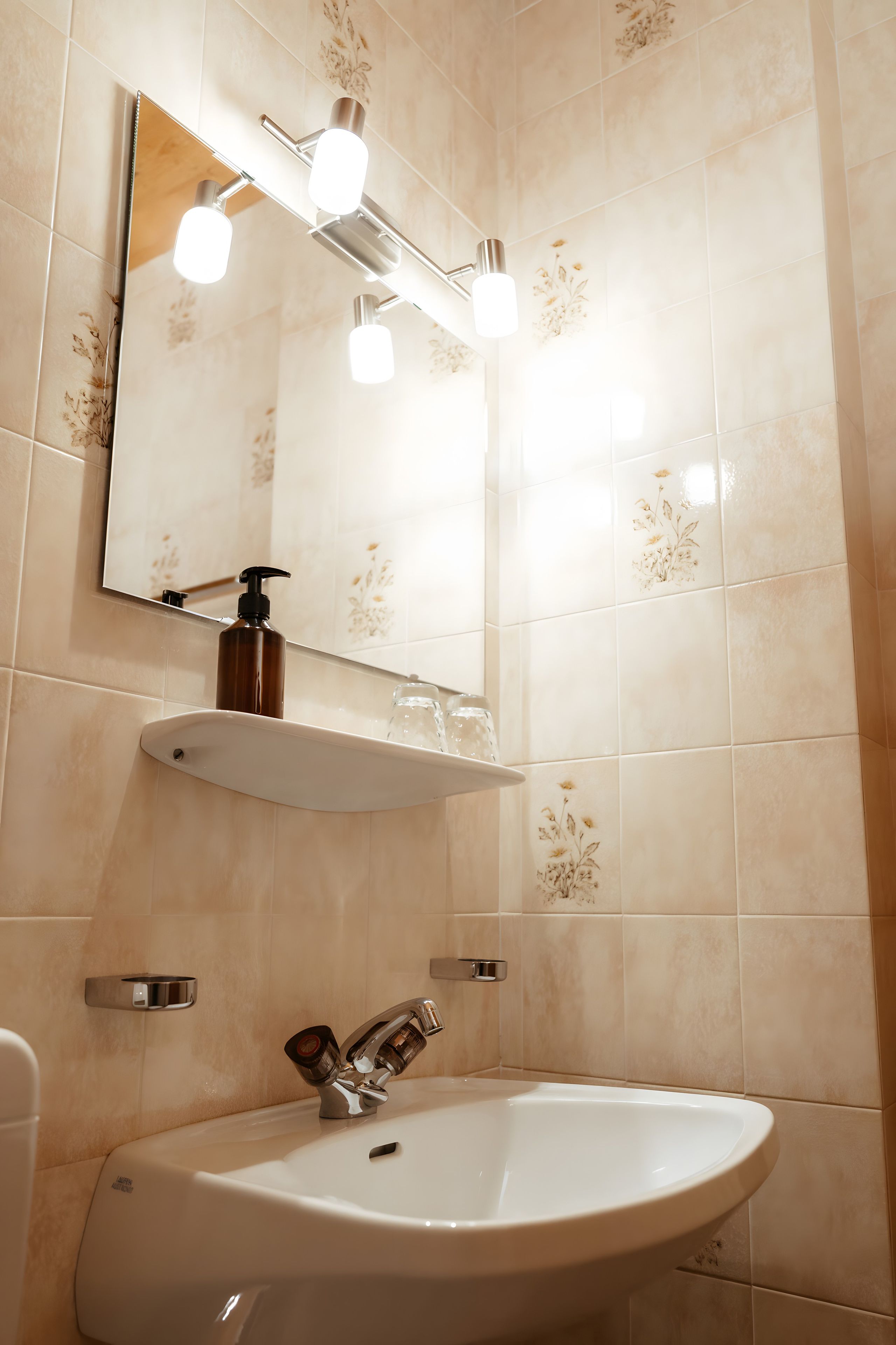 A bathroom with a sink, mirror, and light fixture.