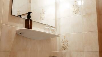 A bathroom with a sink, mirror, and light fixture.