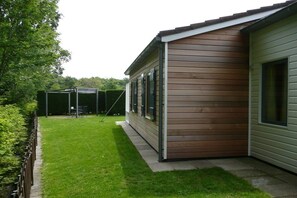 Een modern huis met een verzorgd gazon en een overdekt terras.