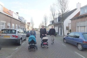 Een woonstraat met geparkeerde auto's en huizen.