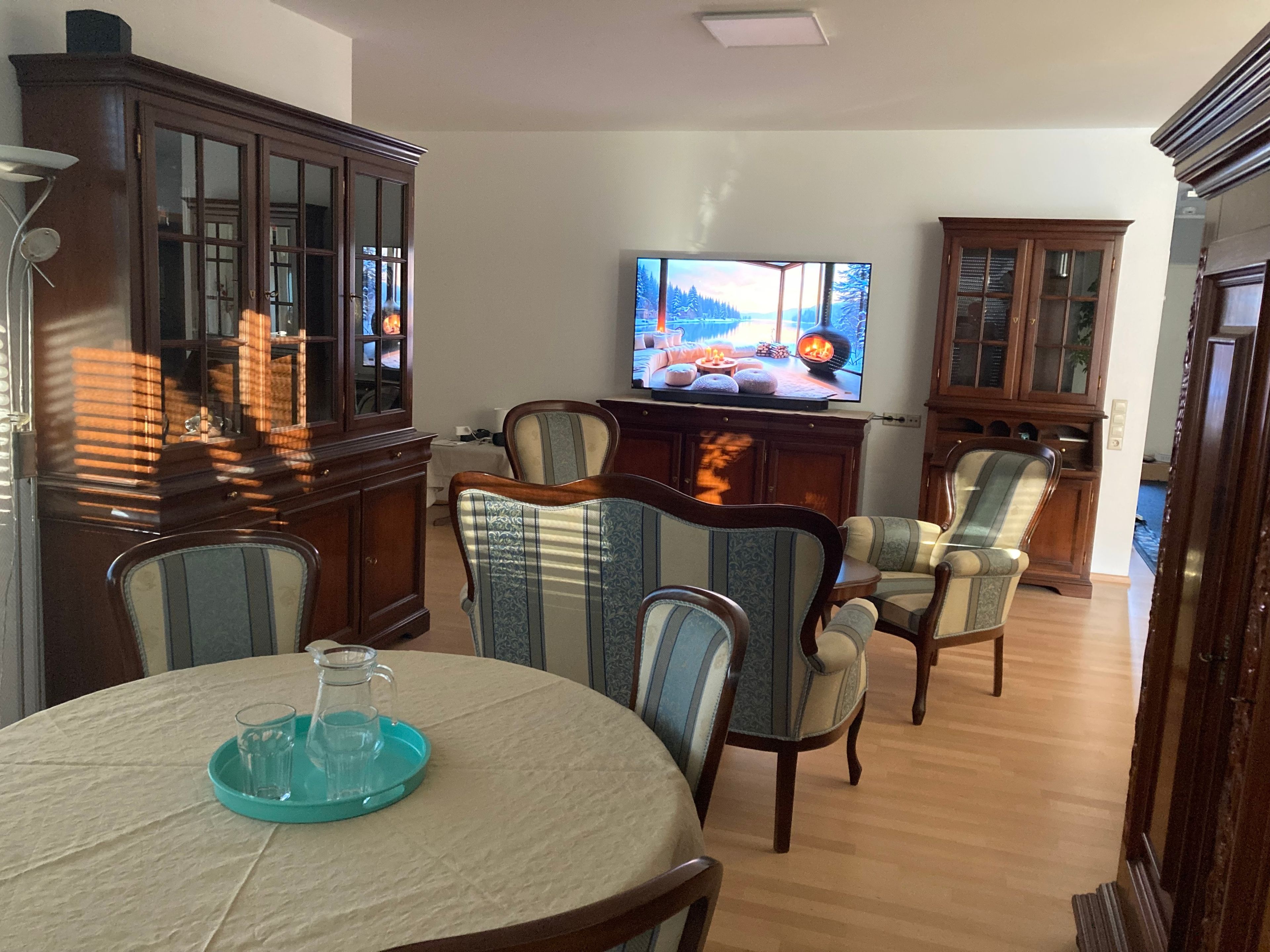 A living room with a television, wooden furniture, and a fireplace.