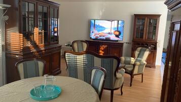 A living room with a television, wooden furniture, and a fireplace.