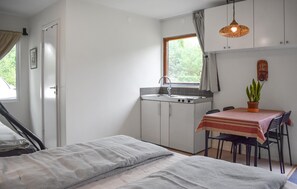 A compact room with a kitchenette, a dining area with a table and chairs, and a bed with a headboard. - 1 bedroom awesome home in Hörby (Hörby)