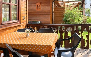 A wooden deck with a table and chairs, a wooden fence, and a view of greenery. - Pet friendly home in Pobierowo with WiFi (Pobierowo)