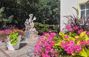 A garden with a stone sculpture, potted plants, and a building in the background. - Pet friendly home in Pobierowo with WiFi (Pobierowo)