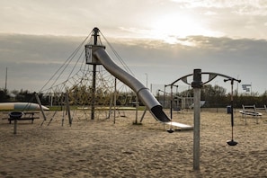 Une aire de jeux avec un toboggan et des structures d’escalade.