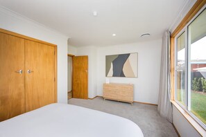 Ein Schlafzimmer mit einem großen Bett, einem Holzschrank, einem Schminktisch und einem Bild an der Wand.