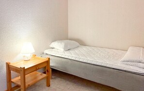 A small, single-bed room with a wooden desk and a lamp. - 3 bedroom pet friendly home in Stugun (Stugun)
