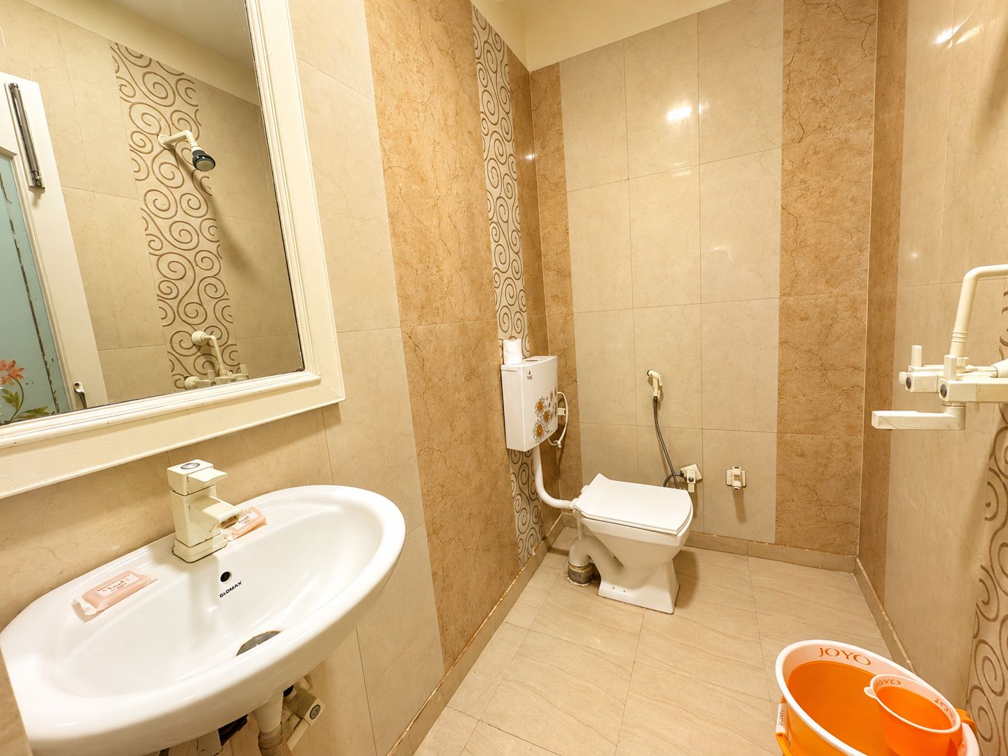 A bathroom with a sink, toilet, shower, and a mirror.