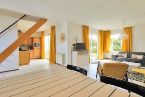 A modern apartment with a dining area, kitchen, living room, and a staircase. - Holiday home in Callantsoog with barbecue (Callantsoog)