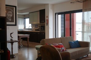 A living room with a sofa, a coffee table, and a dining area with a table and chairs.