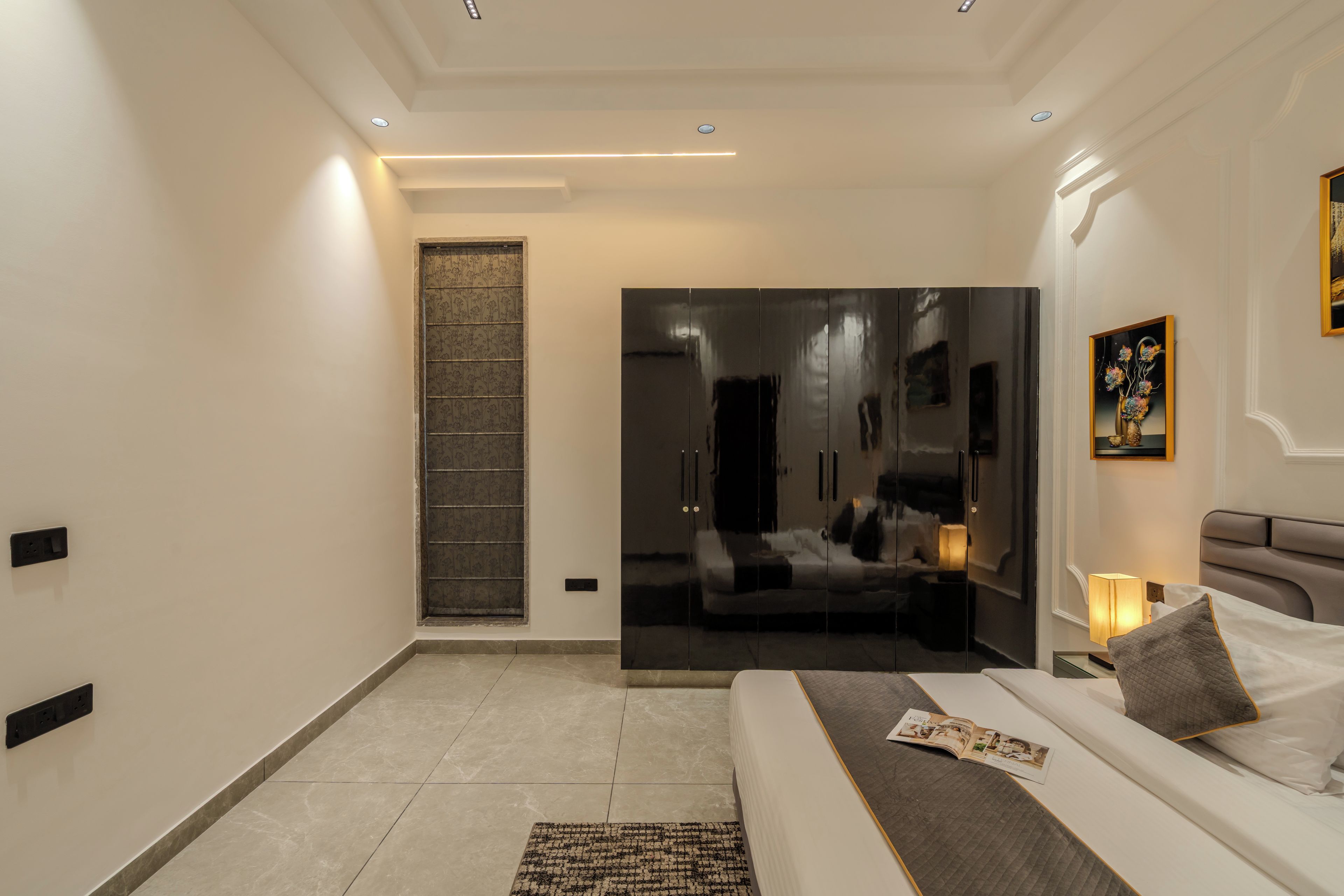 Une chambre à coucher moderne avec un lit, une table de chevet et un miroir.