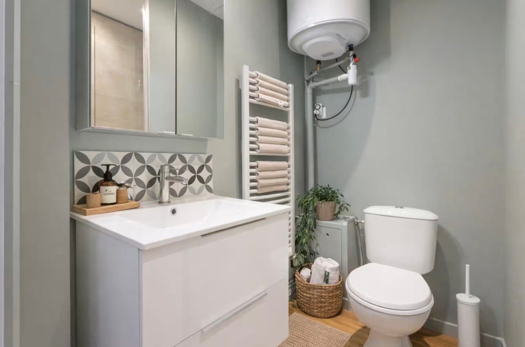 A modern bathroom with a white sink, a toilet, and a towel rack.