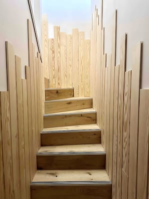 Una escalera de madera con vistas al cielo en la parte superior.