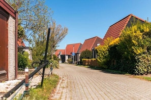 Een woonstraat met huizen, een verharde weg en een fiets.