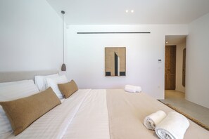 Een moderne hotelkamer met een groot bed, een hoofdbord, een kunstwerk aan de muur en een zichtbare thermostaat.