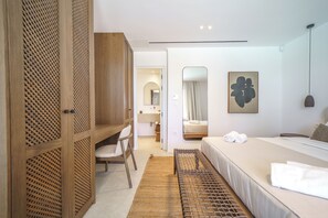 A modern hotel room with a bed, a desk, and a wardrobe. - Secluded Cycladic serenity meets an endless blue horizon in Mykonos (Mykonos)