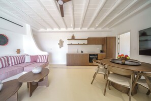 Un espace de vie moderne comprenant un canapé, une table à manger et un coin cuisine.
