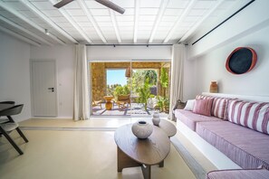 Un salon moderne avec un canapé, une table basse et un mur en pierre.