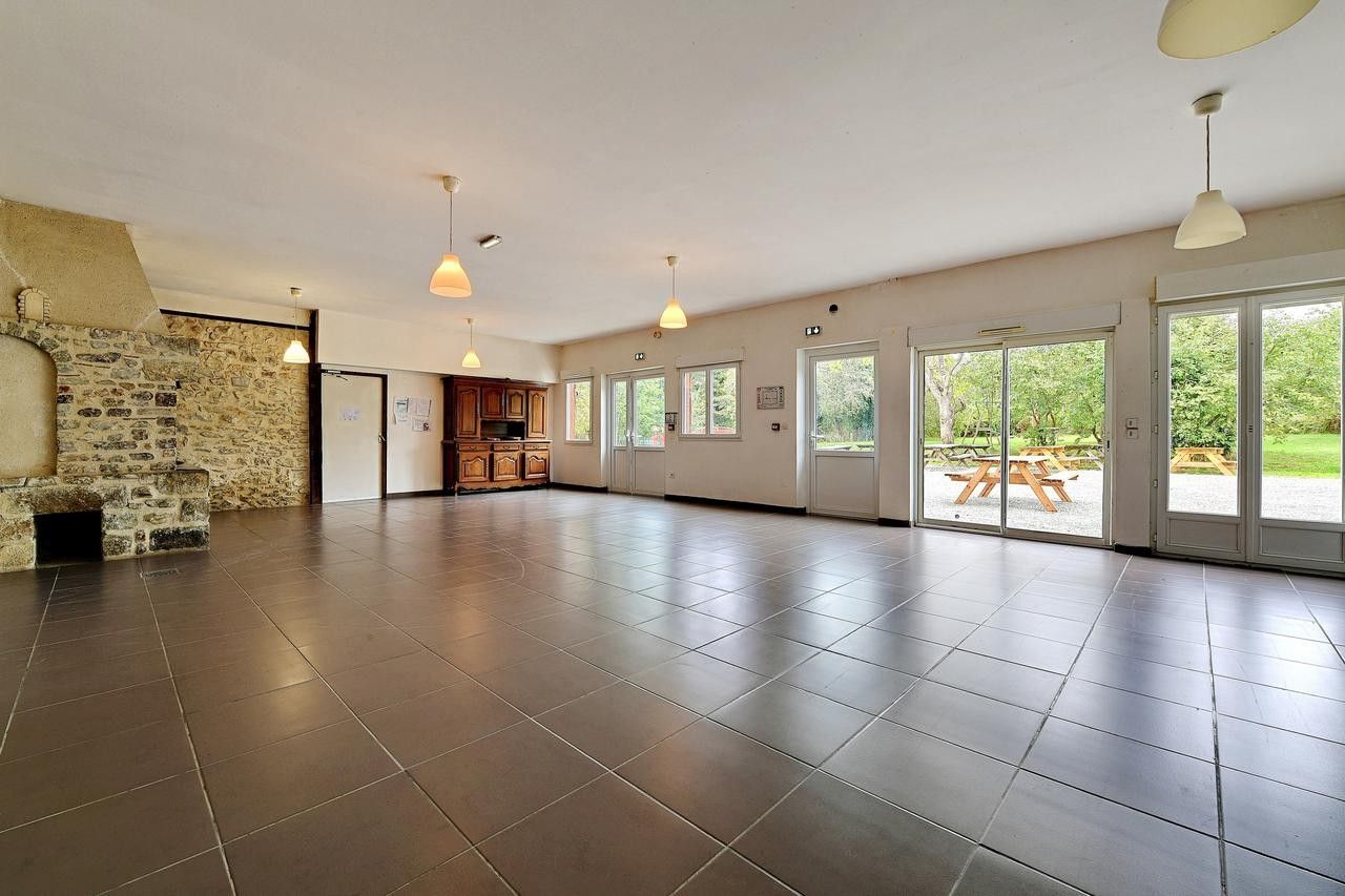 A spacious room with a stone wall, large windows, and a view of the outdoors.