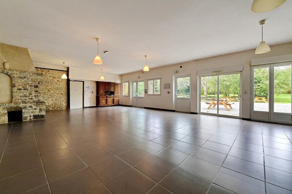 A spacious room with a stone wall, large windows, and a view of the outdoors.