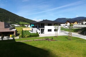 A residential area with modern houses, a clear sky, and a mountainous backdrop. - Holiday apartment with 2 bedrooms (Eben im Pongau)