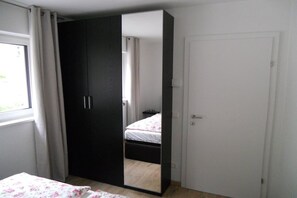 Un dormitorio con cama, armario y puerta.