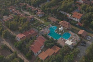 An aerial view of a residential area with multiple houses, a swimming pool, and a small garden area. - Apartment with shared pool near the sea (Nicotera (VV))