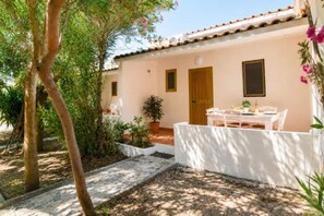 A building with a tiled roof, a door, and a table with chairs outside. - Apartment with Pool by the Sea in Nicotera (Nicotera (VV))