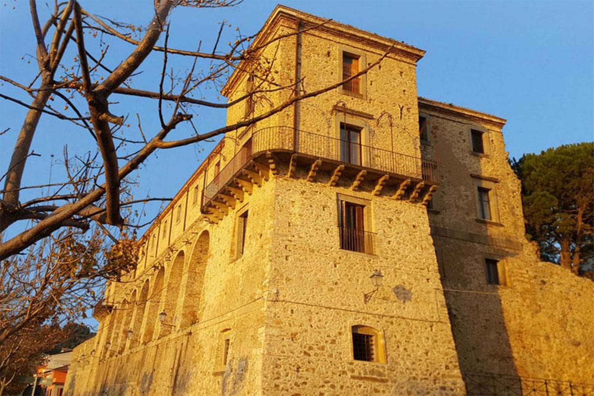 A historic stone building with multiple windows and a balcony.