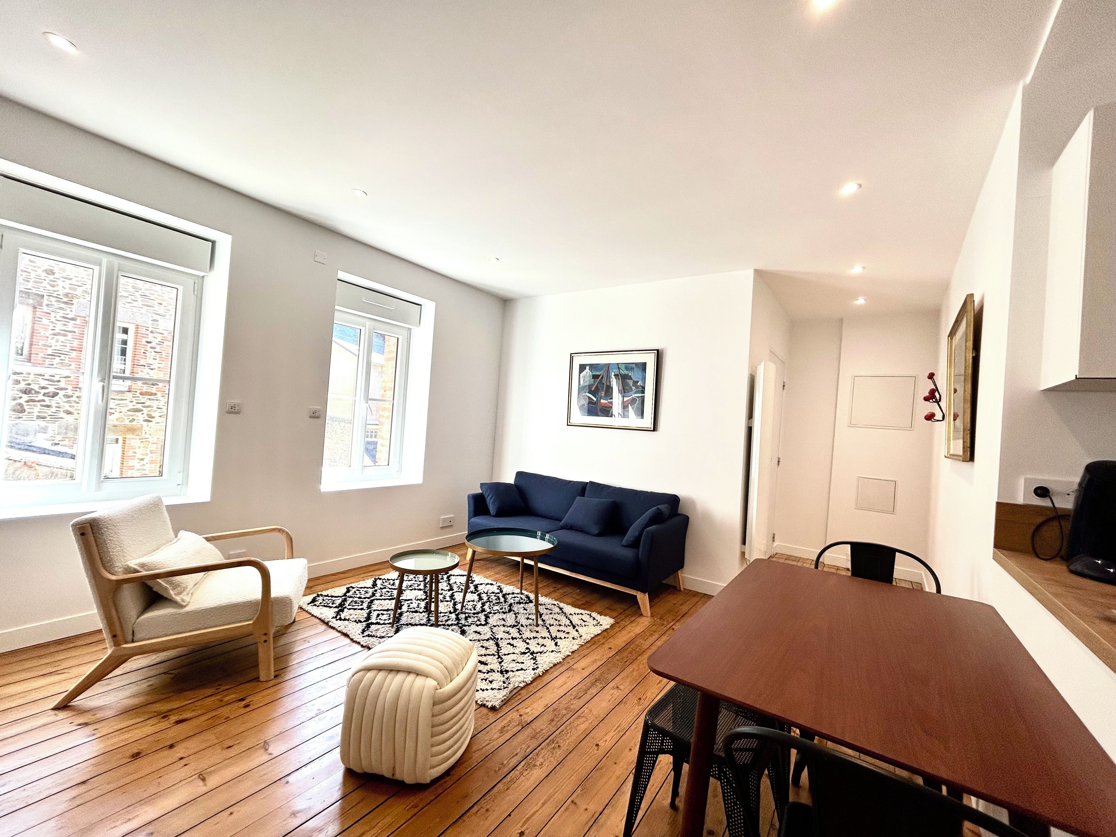 Una sala de estar moderna con un sofá, una mesa de comedor y una mesa de centro.