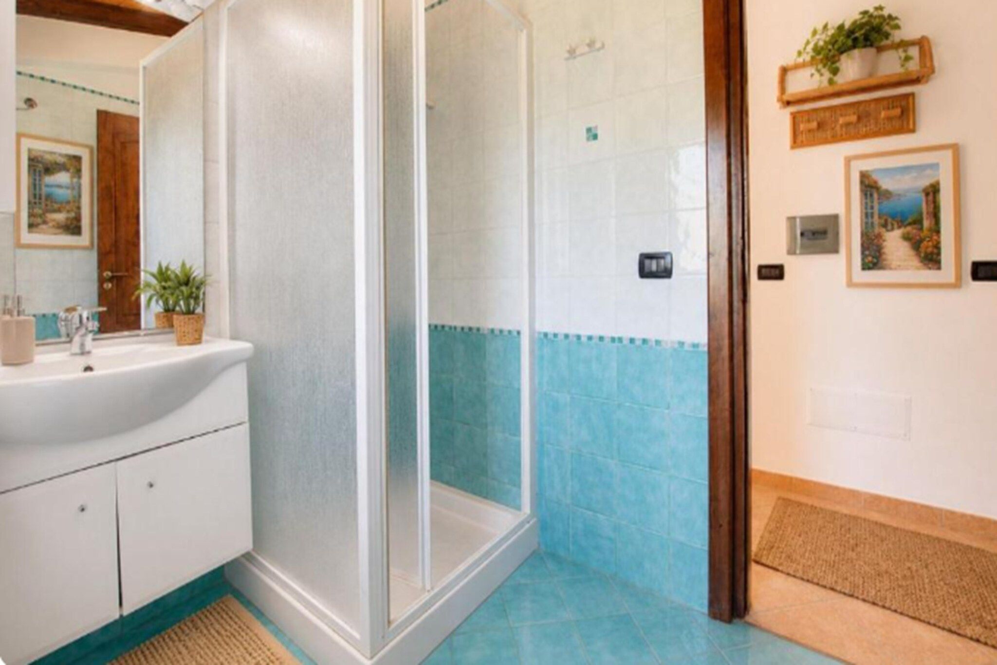 Ein Badezimmer mit Dusche, Waschbecken und Fliesenboden.